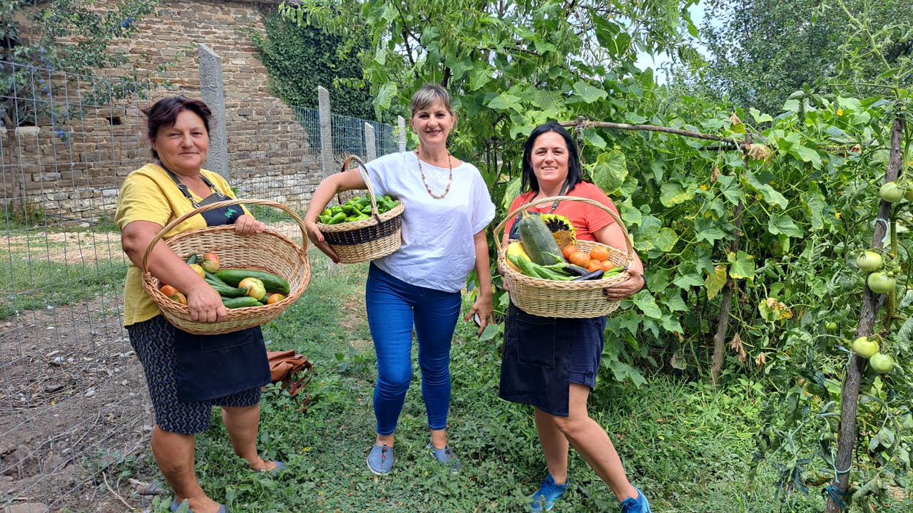 Women holding fruit baskets in a garden